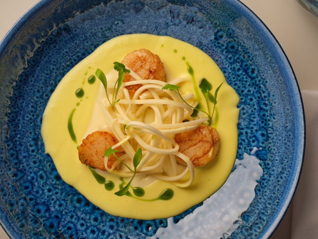 A plate with samphire and scallops.